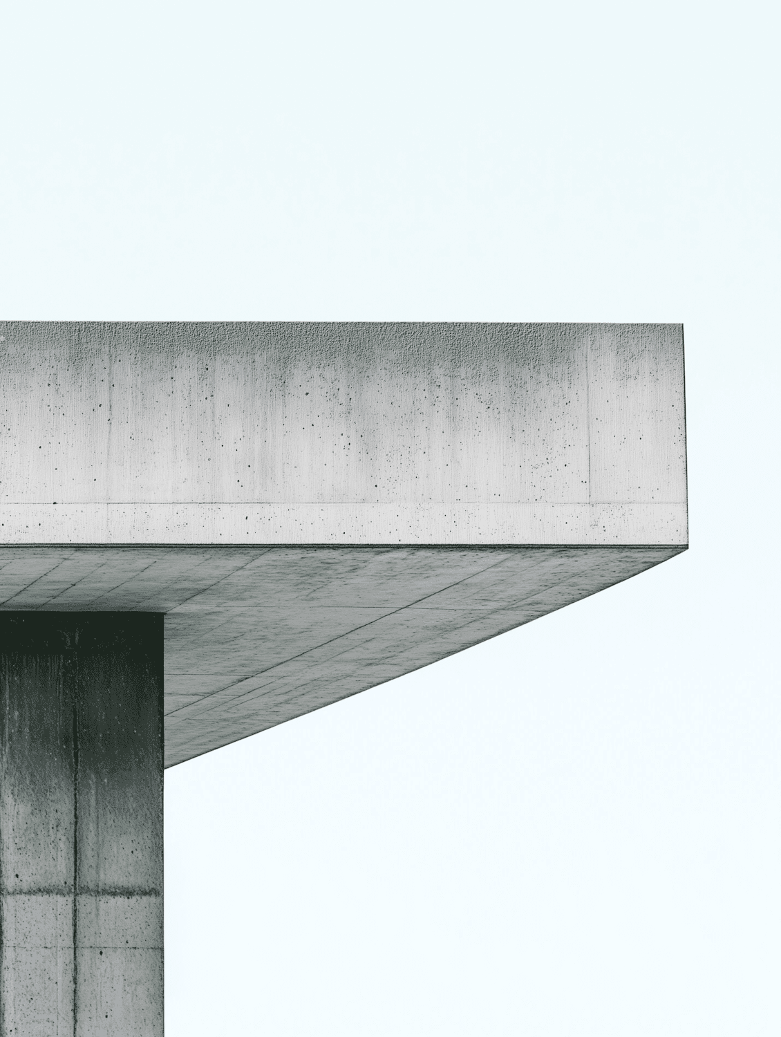 Concrete structural frame of a building in progress against a pale sky
